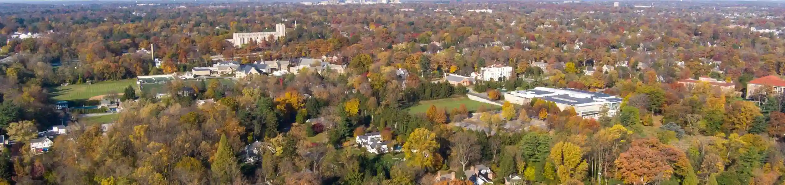 Aerial view of Towson, Maryland, with tree-lined neighborhoods and buildings surrounded by fall foliage
