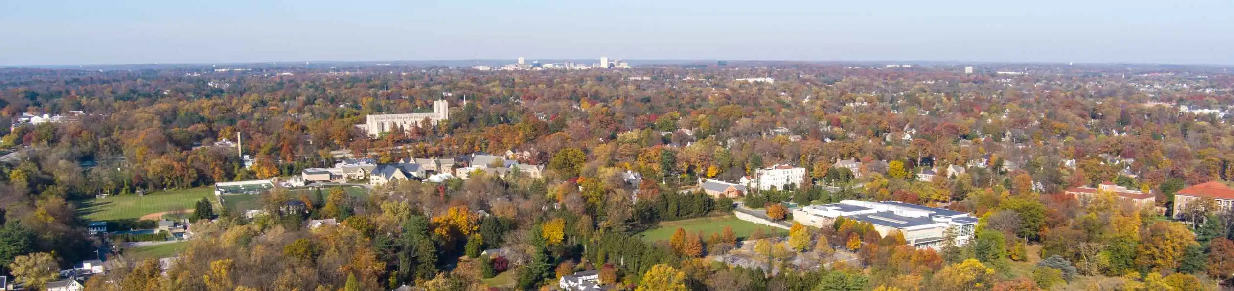 Aerial view of Towson, Maryland, with tree-lined neighborhoods and buildings surrounded by fall foliage